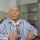 Luo Danhong holding a picture of him wearing the People’s Volunteer Army uniform during the Korean war.